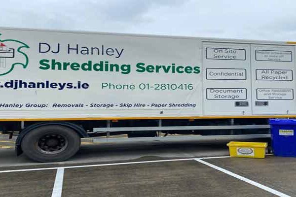 Confidential Paper Shredding Truck with a yellow crate and blue wheelie Bin in front of it.